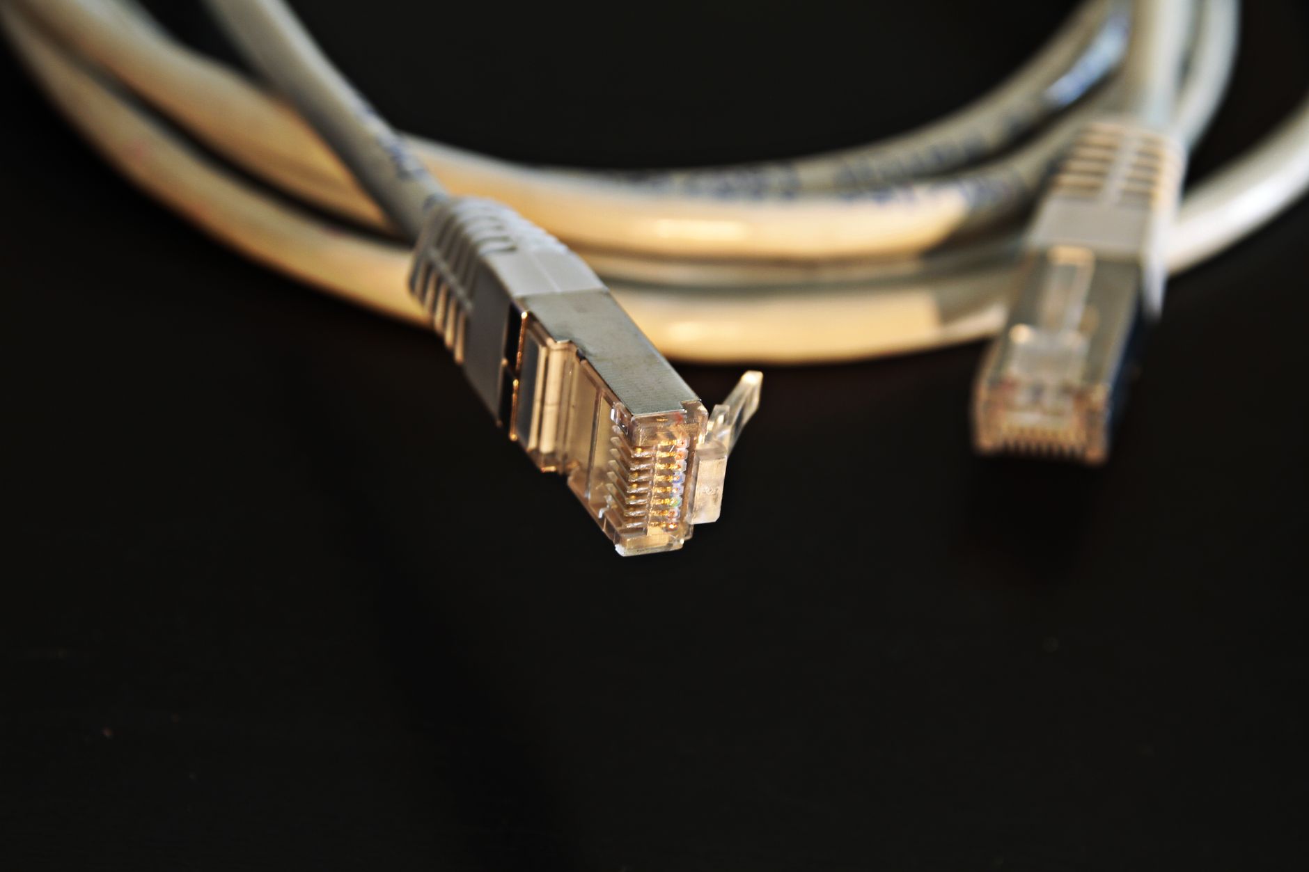 Many glowing network cables converging into a single connector with one cable unplugged